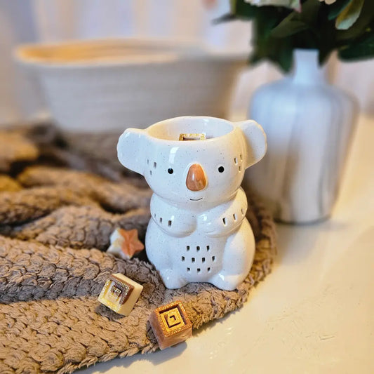 Brûle-parfums en forme de koala sur plaid cocooning