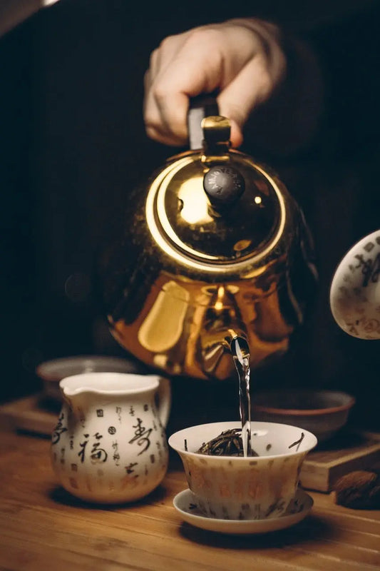 bouilloire verse de l'eau chaude dans tasse de thé noir