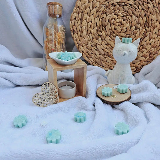 Fondants parfumés bleu cyan et brûle-parfum dans un décor blanc